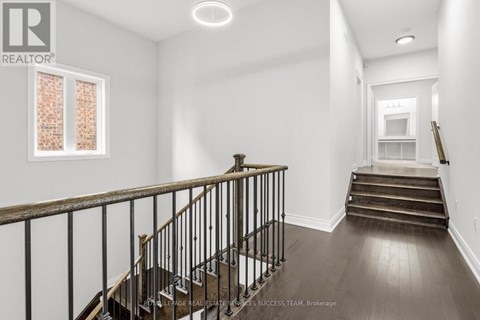 A spacious room with a staircase leading to the second floor.