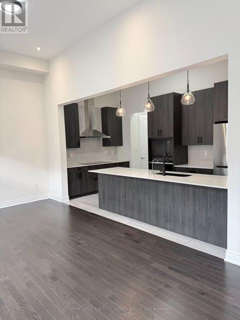 A modern kitchen with dark wood floors and a white countertop.