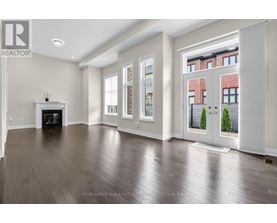 A spacious living room with a fireplace and hardwood floors.