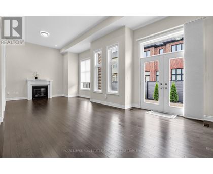 A spacious living room with a fireplace and hardwood floors.