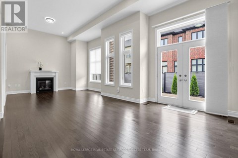 A spacious living room with a fireplace and hardwood floors.