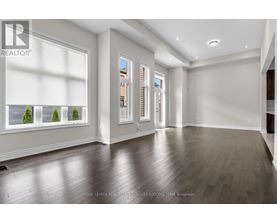 A spacious room with wooden flooring and a large window.