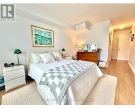 A bedroom with a bed, nightstand, and lamp.