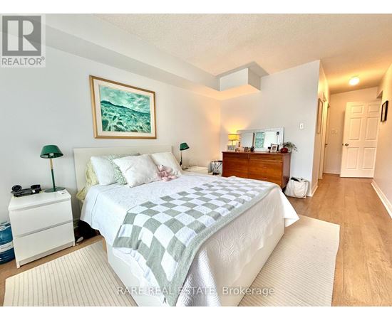 A bedroom with a bed, nightstand, and lamp.