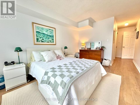 A bedroom with a bed, nightstand, and lamp.
