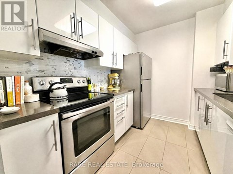 A kitchen with white cabinets and stainless steel appliances.