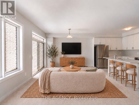 A living room with a couch, a television, and a kitchen area in the background.
