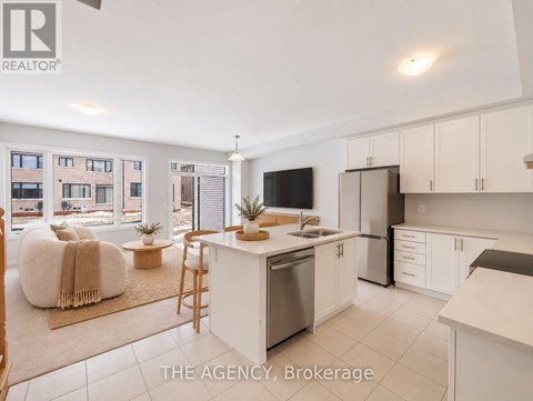 A well-lit kitchen with white cabinets and a large island.