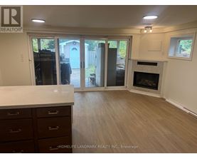 A realtor photo of a room with a fireplace and sliding glass doors.