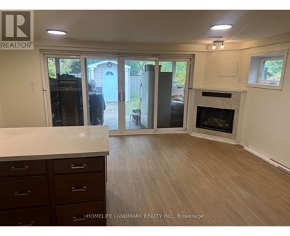 A realtor photo of a room with a fireplace and sliding glass doors.
