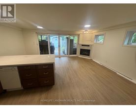 A spacious room with wooden flooring and a washing machine in the corner.