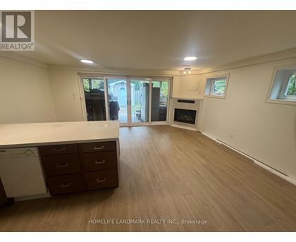 A spacious room with wooden flooring and a washing machine in the corner.