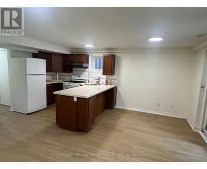 A kitchen with a white fridge and wooden cabinets.