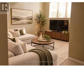 A living room with a couch, a coffee table, a television, and a plant.