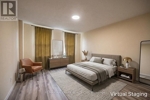 A bedroom with a bed, chair, and nightstand.
