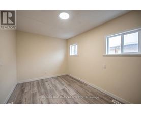 A room with a window and a wooden floor.