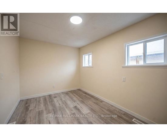 A room with a window and a wooden floor.