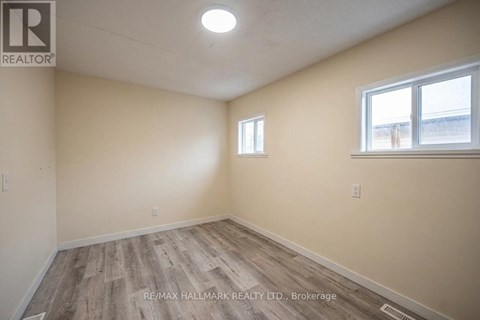 A room with a window and a wooden floor.