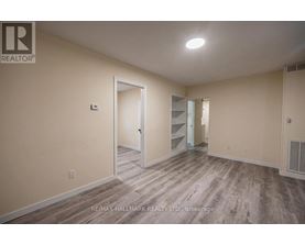 A spacious room with a doorway leading to another room.