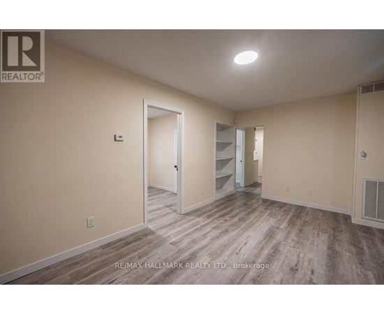 A spacious room with a doorway leading to another room.