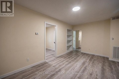 A spacious room with a doorway leading to another room.