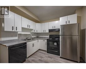 A kitchen with white cabinets and stainless steel appliances.