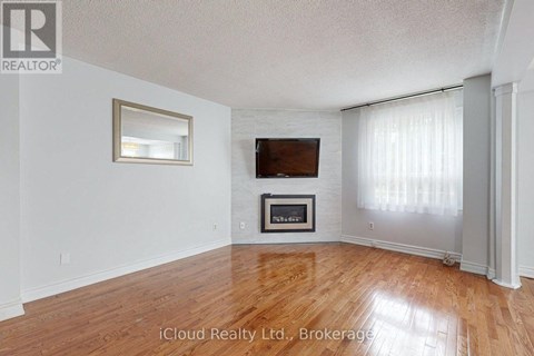 A living room with a fireplace and a flat screen TV.