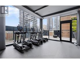 A room with a row of treadmills and a view of the city outside the window.