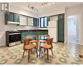 A kitchen with green cabinets and a patterned floor.