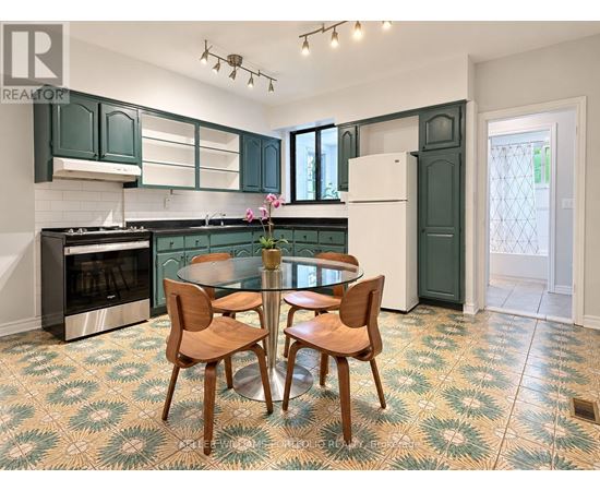 A kitchen with green cabinets and a patterned floor.