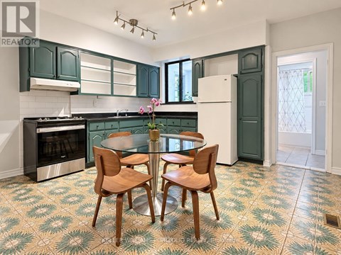 A kitchen with green cabinets and a patterned floor.