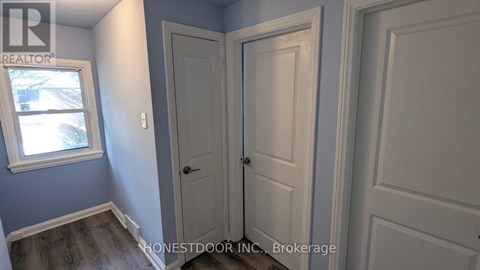 A room with a white door and a window with a view of a snowy landscape.