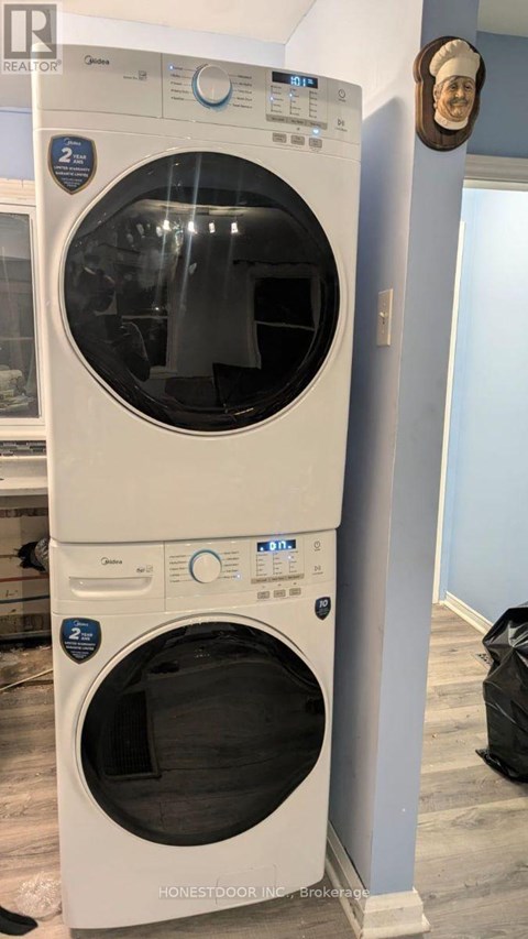 A white washing machine with the door open is in a room.