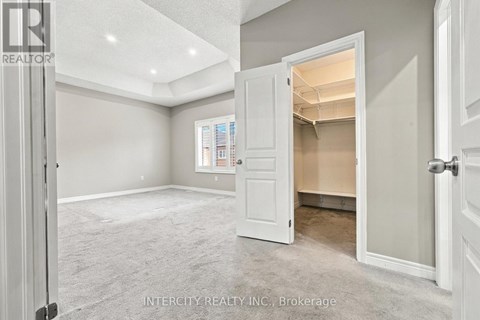 A spacious room with a doorway leading to another room.