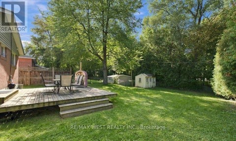 A backyard with a deck and a small shed.