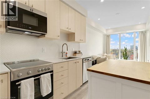 A modern kitchen with a stainless steel oven and microwave above the counter.