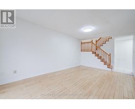 A room with a wooden floor and a staircase.
