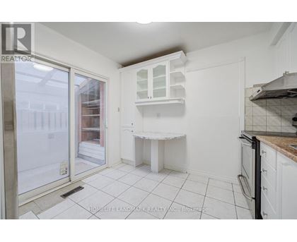 A kitchen with white cabinets and a white countertop.