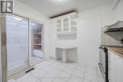A kitchen with white cabinets and a white countertop.