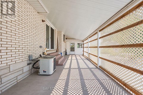 A long hallway with a brick wall and a white ceiling.