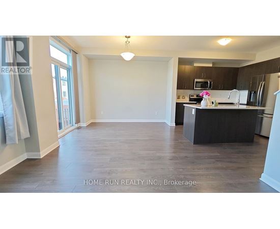 A spacious kitchen and living room with a dining table and chairs.