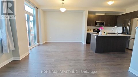 A spacious kitchen and living room with a dining table and chairs.