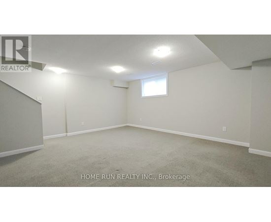 A spacious room with a window and carpeted floor.