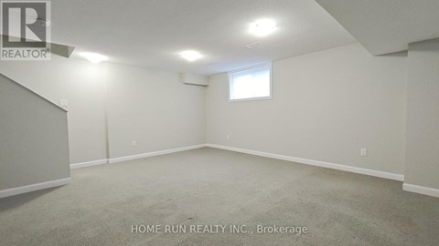 A spacious room with a window and carpeted floor.