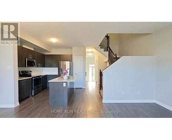 A spacious kitchen with dark wood cabinets and a white island.
