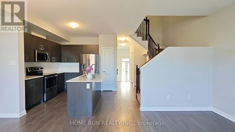A spacious kitchen with dark wood cabinets and a white island.