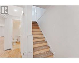A staircase with wooden steps and a white wall.
