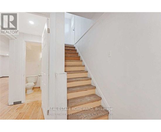 A staircase with wooden steps and a white wall.