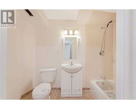 A white bathroom with a toilet, sink, and bathtub.