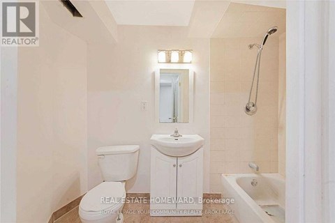 A white bathroom with a toilet, sink, and bathtub.